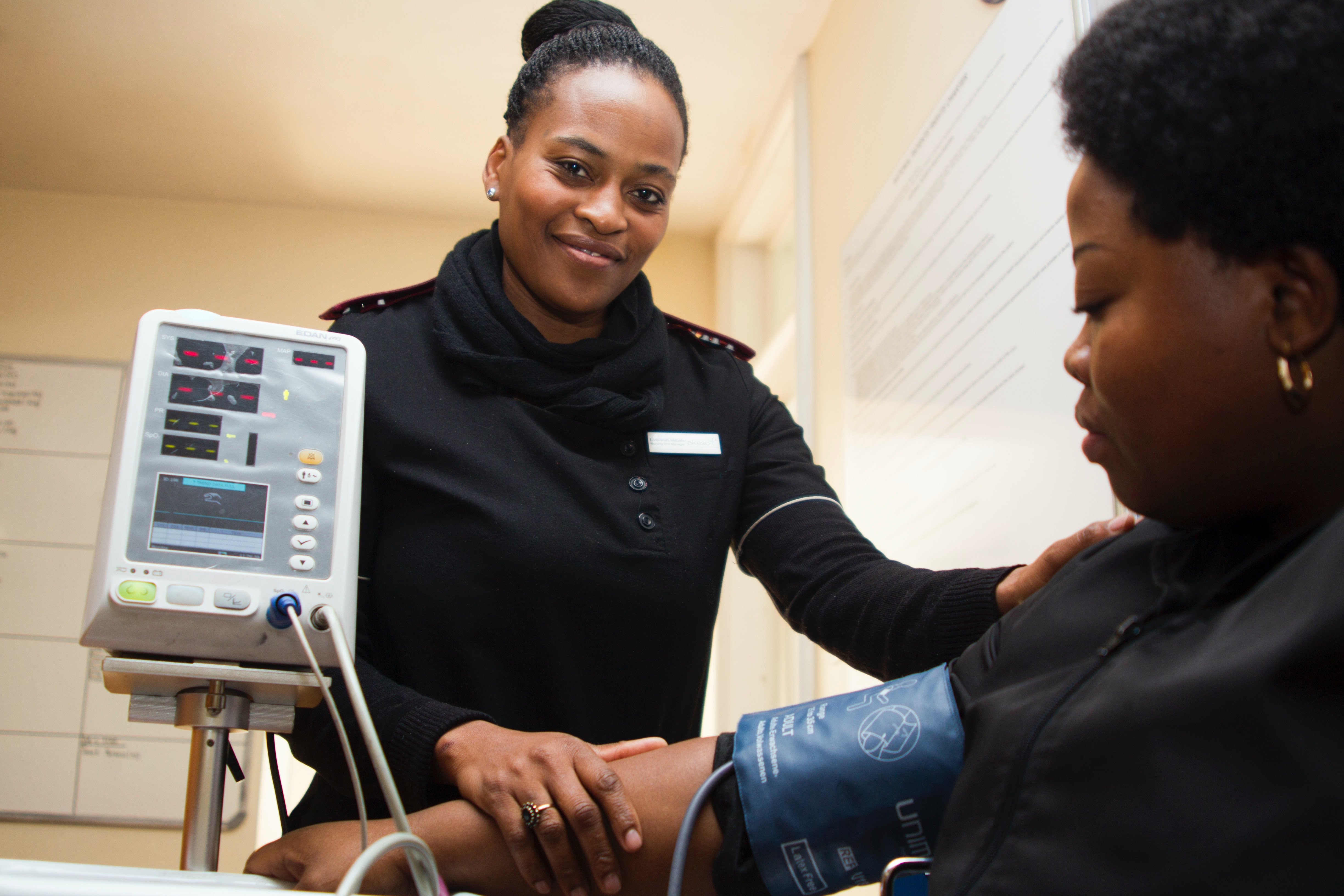 Woman taking blood pressure of another woman